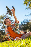 Young Boy Playing WIth Toy Model Airplane Outside