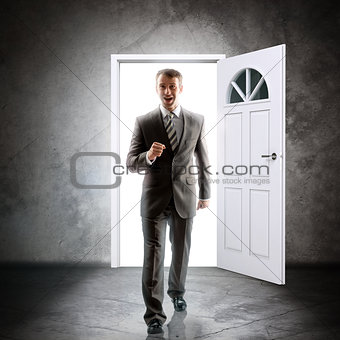 Businessman comes inside through door