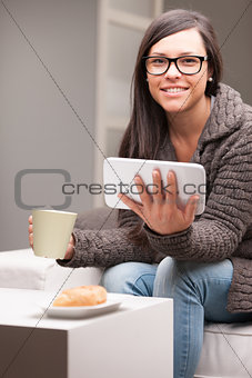 woman with glasses tablet and a mug