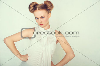Close-up portrait of offended beautiful girl. with funny hairstyle looking at camera.