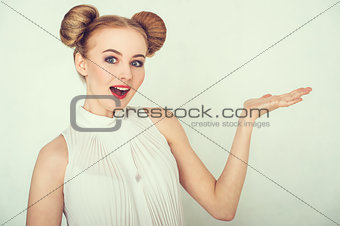 Close-up portrait of surprised beautiful girl. with funny hairstyle, open hand and open-mouthed.
