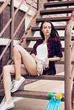 Hipster girl on metal stairs.