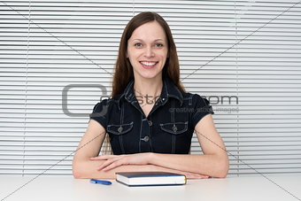 Young businesswoman sitting on the desk