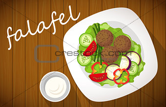 Plate of falafel with tzatziki sauce on wooden table. Top view.