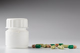 Medicine white bottle and various colorful capsules