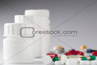 White medicine bottle and various colorful pills
