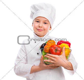 funny little boy-cook holding bowl with vegetables in hands
