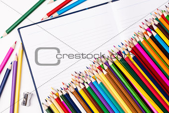 Bunch of color pencils and notebook