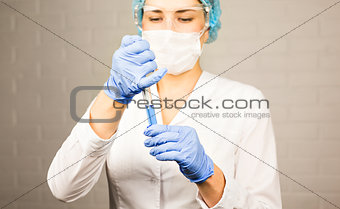 science, chemistry, biology, medicine and people concept - close up of young female scientist holding test tube  making research in clinical laboratory.
