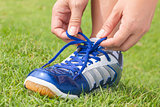 Girl is tying shoes laces for jogging at park.