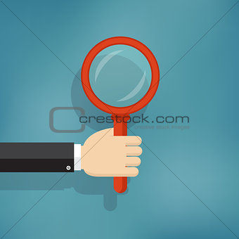 hand holding magnifying glass.