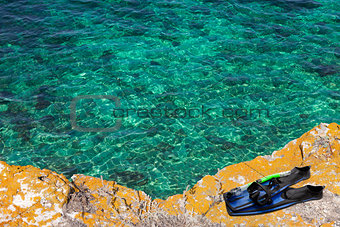 Mask, snorkel and flippers on the cliff of sea
