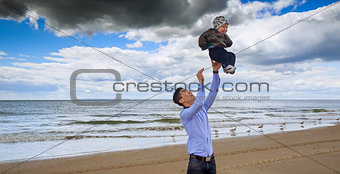 Father and son having fun white sand beach