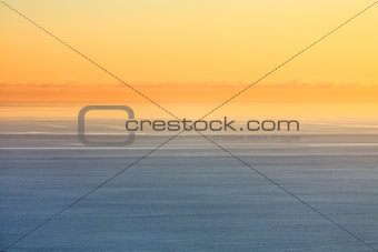 Orange sunset sky over blue sea