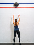 Woman throwing the medicine ball at the gym