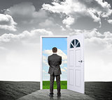 Businessman with door in colorful nature