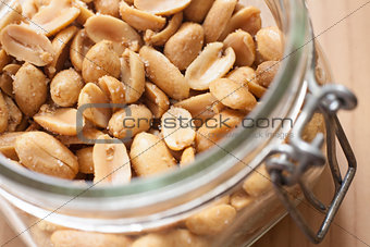 Open canning jar with fried salty peanuts. Overhead view