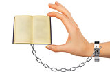 Chained hand holding open book