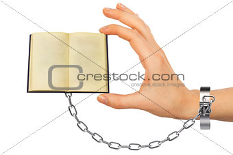 Chained hand holding open book