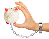 Chained hand holding piggy bank