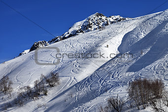 Off-piste slope with track from ski and snowboard on sunny day