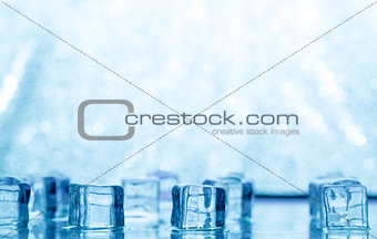 Melting transparent blue ice cubes on glass