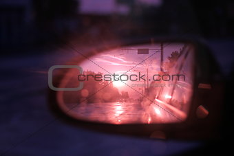 side rear-view mirror in the evening in the city during sunset