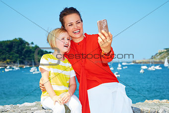 Mother and daughter taking selfie in front of lagoon