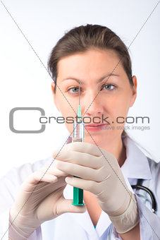 portrait of a nurse with a syringe in gloves