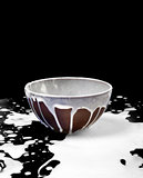 Ceramic bowl and spilled milk in black