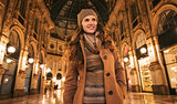 Happy woman in Galleria Vittorio Emanuele II and looking aside