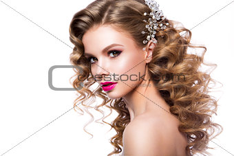 Beautiful young woman with long hair posing on pink shiny background.