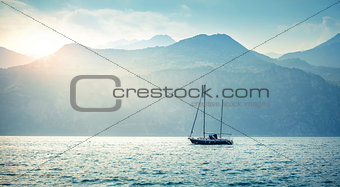 Sailer boat sailing by sea waves in evening