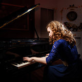 Young woman playing the grand piano