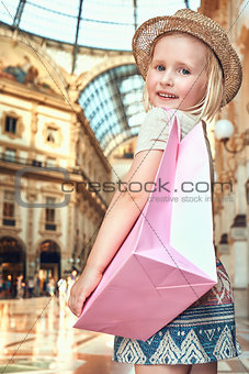 Portrait of smiling fashion girl with shopping bag in Galleria