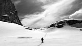 Hiker on snow plateau. Black and white panoramic view.