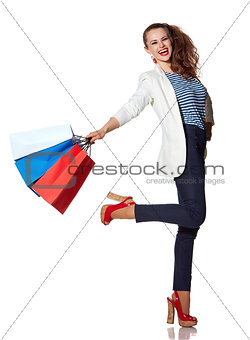 Smiling woman with shopping bags posing on white background