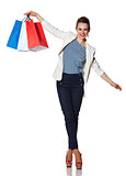 Happy woman with shopping bags balancing on white background
