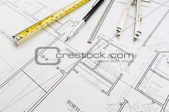 Measuring Tape, Pencil, Ruler and Compass Resting on House Plans