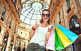 Happy woman with shopping bags in Galleria Vittorio Emanuele