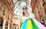 Happy woman with shopping bags in Galleria Vittorio Emanuele