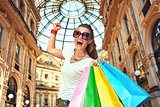 Happy fashion woman with shopping bags rejoicing in Galleria