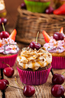 Delicious cupcakes decorated with caramel and fresh berries