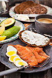 Breakfast with salmon, eggs, avocado, bread, cheese and coffee