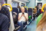 Woman using mobile phone while travelling by train.