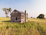 Dilapidated house in field.