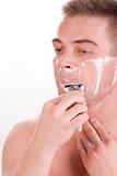 Man is shaving his chin