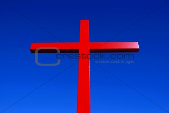 Red Christian cross against blue sky