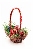 Basket with grass and colored Easter eggs