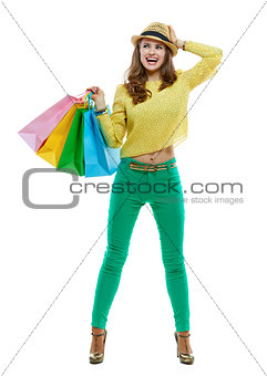 Excited woman with shopping bags looking aside, white background